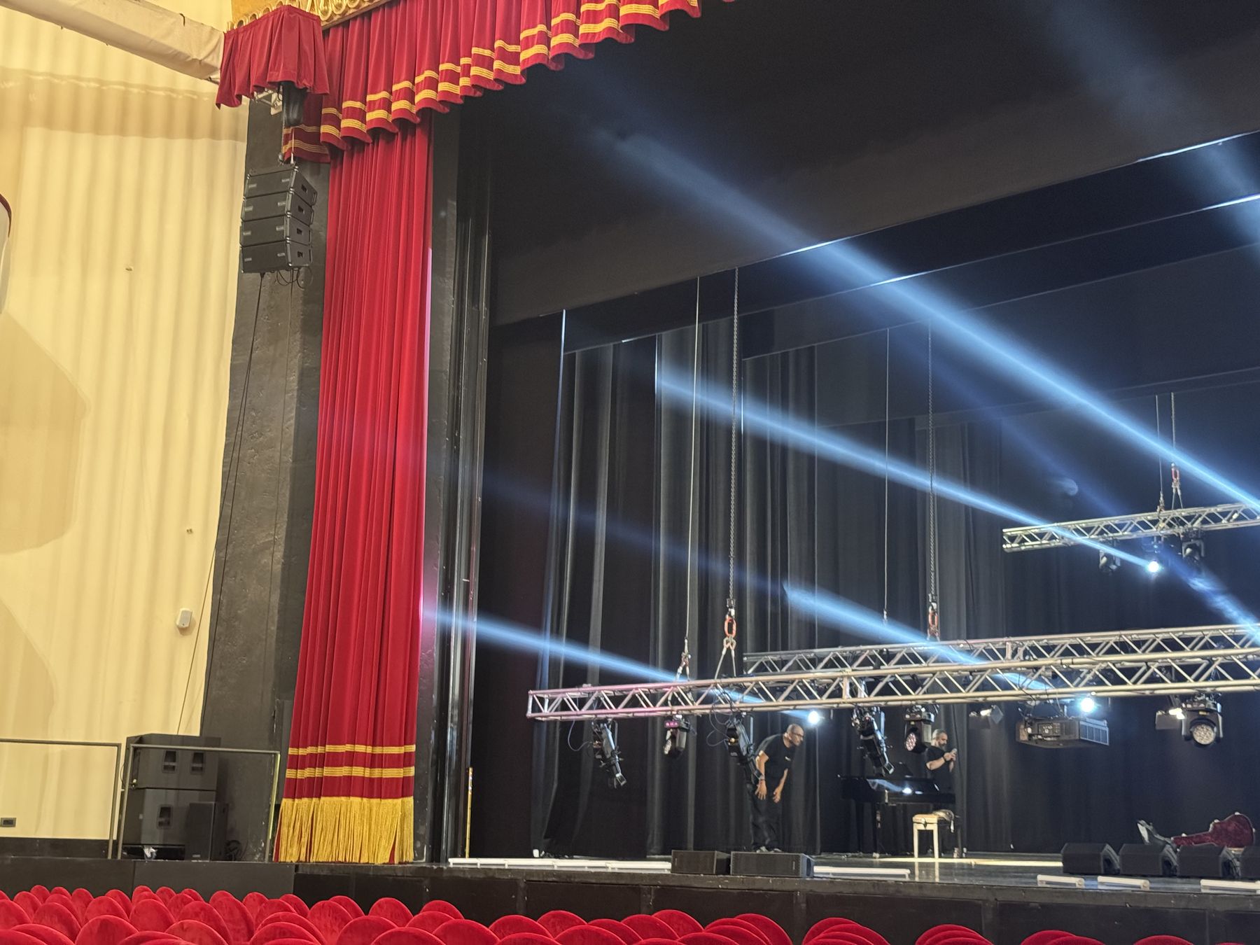 Prova dei fasci luce dietro il sipario rosso del Teatro Lirico
